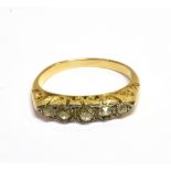 AN EARLY 20TH CENTURY GOLD AND DIAMOND FIVE STONE CARVED HALF-HOOP RING the graduated old-mine