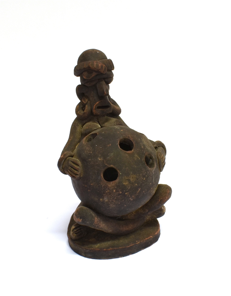 AN AFRICAN TERRACOTTA TRIBAL FIGURE modelled as a seated female, holding a large ball, possibly a