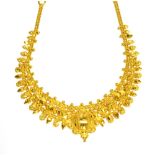 AN INDIAN HIGH CARAT NECKLACE the front designed as a central raised oval panel decorated with
