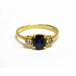 AN 18CT GOLD, SAPPHIRE AND DIAMOND THREE STONE RING centred with a small oval very dark-blue mixed-