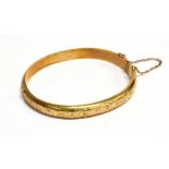 A 9CT GOLD PART FOLIATE ENGRAVED HOLLOW 'D' SECTION HINGED BANGLE Birmingham 1963, 10.6g