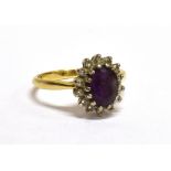 AN 18CT GOLD. AMETHYST AND DIAMOND OVAL CLUSTER RING centred with an oval mixed-cut amethyst