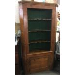 A LARGE PITCH PINE CORNER CUPBOARD with three shaped shelves and cupboard to base, 104 cm wide 192cm