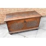 AN OAK COFFER WITH CARVED DECORATION TO FRONT AND SIDES on bun feet, 11cm wide 53cm deep 58cm high