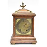 AN EDWARDIAN 8-DAY MANTLE CLOCK the silvered dial with Roman numberals and brass cherub spandrels,