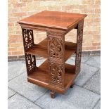 AN EDWARDIAN REVOLVING BOOKCASE the 57cm square top with moulded edge, pierced fretwork decoration