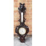 A BLACK FOREST BAROMETER/THERMOMETER BY DOLLOND the carved oak frame incorporating oak leaves, a