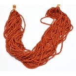 A RED CORAL MULTI-STRAND NECKLACE of 30 rows of small barrel-shaped beads approx. 2.2-2.5mm overall,