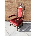 A HIGHLY CARVED OAK ARMCHAIR with upholstered seat, back and armrests