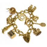 A 9CT GOLD CURB-LINK 'CHARM' BRACELET on a padlock clasp, London 1971, and hung with eleven