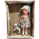 A SMALL PAINTED PLASTER DOLL & HER DOG circa 1930s, 14.5cm high, in original box.