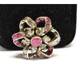 A RUBY AND DIAMOND FLOWER HEAD CLUSTER BROOCH IN VICTORIAN STYLE centred with a foil-backed
