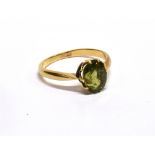 AN EARLY 20TH CENTURY GOLD AND GREEN CHRYSOBERYL SINGLE STONE RING, the oval native-cut stone approx