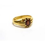 AN 18CT GOLD AND GARNET SINGLE STONE GYPSY RING, the oval mixed-cut stone claw set between