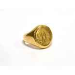 AN ORIENTAL YELLOW METAL OVAL SIGNET RING engraved with script initials 'DK', on a tapering shank