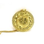 AN ORIENTAL YELLOW METAL ROUND PENDANT AND CHAIN the pendant centred with a Chinese symbol flanked