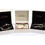 PANDORA; FOUR MODERN CABLE LINK BRACELETS three of which are strung with either twelve beads , eight