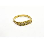 AN EARLY 20TH CENTURY GOLD AND DIAMOND FIVE STONE CARVED HALF-HOOP RING claw set with two small