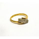AN ART DECO GOLD AND DIAMOND THREE STONE CROSS-OVER RING centred with an old-cut diamond between