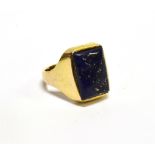 AN ORIENTAL YELLOW METAL AND RECTANGULAR-CABOCHON LAPIS LAZULI SINGLE STONE RING, on a tapering