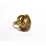 A VINTAGE 9CT GOLD AND SMOKEY QUARTZ SINGLE STONE RING the oval mixed-cut stone in a textured and