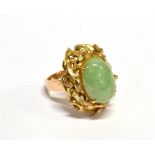 AN ORIENTAL YELLOW METAL AND PALE-GREEN OVAL CABOCHON JADEITE SINGLE STONE RING the slightly mottled