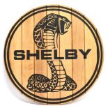 A 'SHELBY' PANELLED CIRCULAR WOODEN SIGN bearing the cobra trademark, 75cm