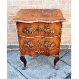 A SMALL CONTINENTAL SERPENTINE FRONT TWO DRAWER COMMODE with rococo style gilt metal mounts, on