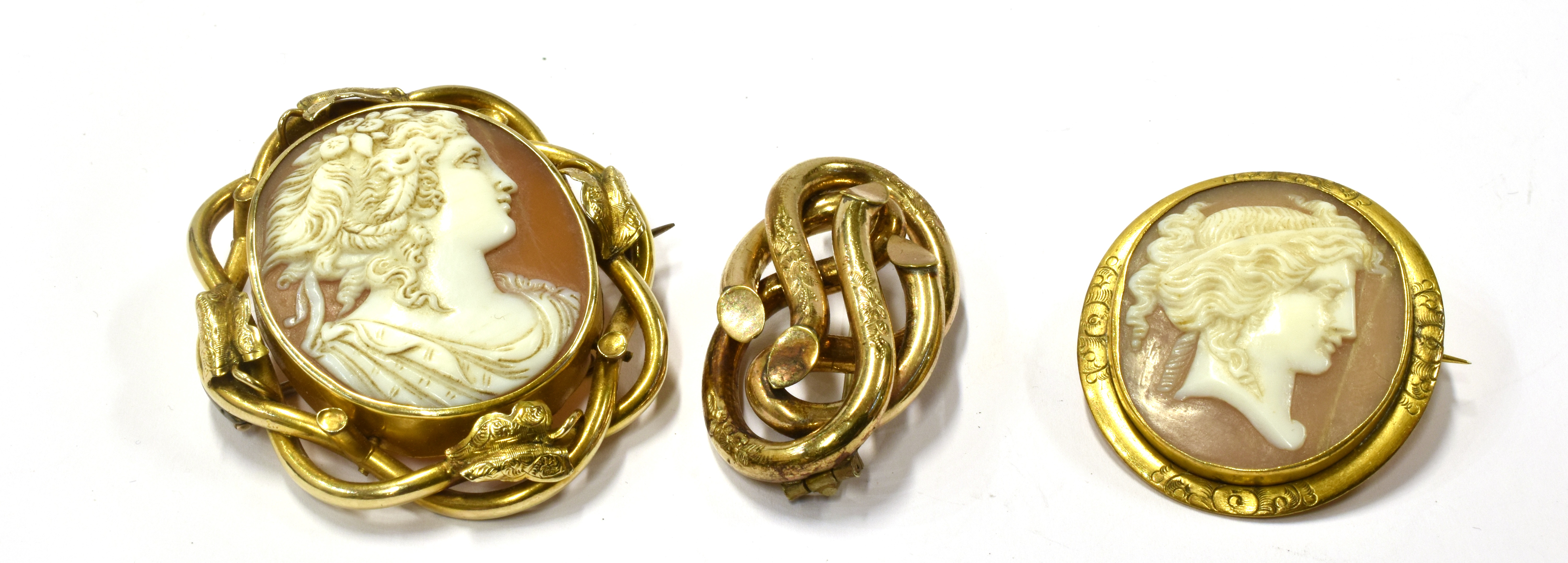 TWO VICTORIAN SHELL CAMEO BROOCHES AND A KNOT BROOCH the larger cameo depicting a neoclassical