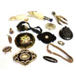 A COLLECTION OF FIVE MOURNING BROOCHES, A PAPIER MACHE ROUND BROOCH AND A VULCANITE OVAL LOCKET with