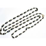 AN EARLY 20TH CENTURY GOLD AND SARDONYX NECKLACE in the form of 65 sardonyx oval beads graduated