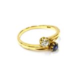 AN EARLY 20TH CENTURY GOLD, SAPPHIRE AND DIAMOND TWO STONE CROSS-OVER RING claw set with a small