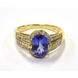A MODERN 18CT GOLD, TANZANITE AND DIAMOND OVAL CLUSTER RING centred with an oval mixed-cut tanzanite
