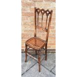 A VICTORIAN CHILDS CORRECTIONAL CHAIR with caned seat, 99cm high