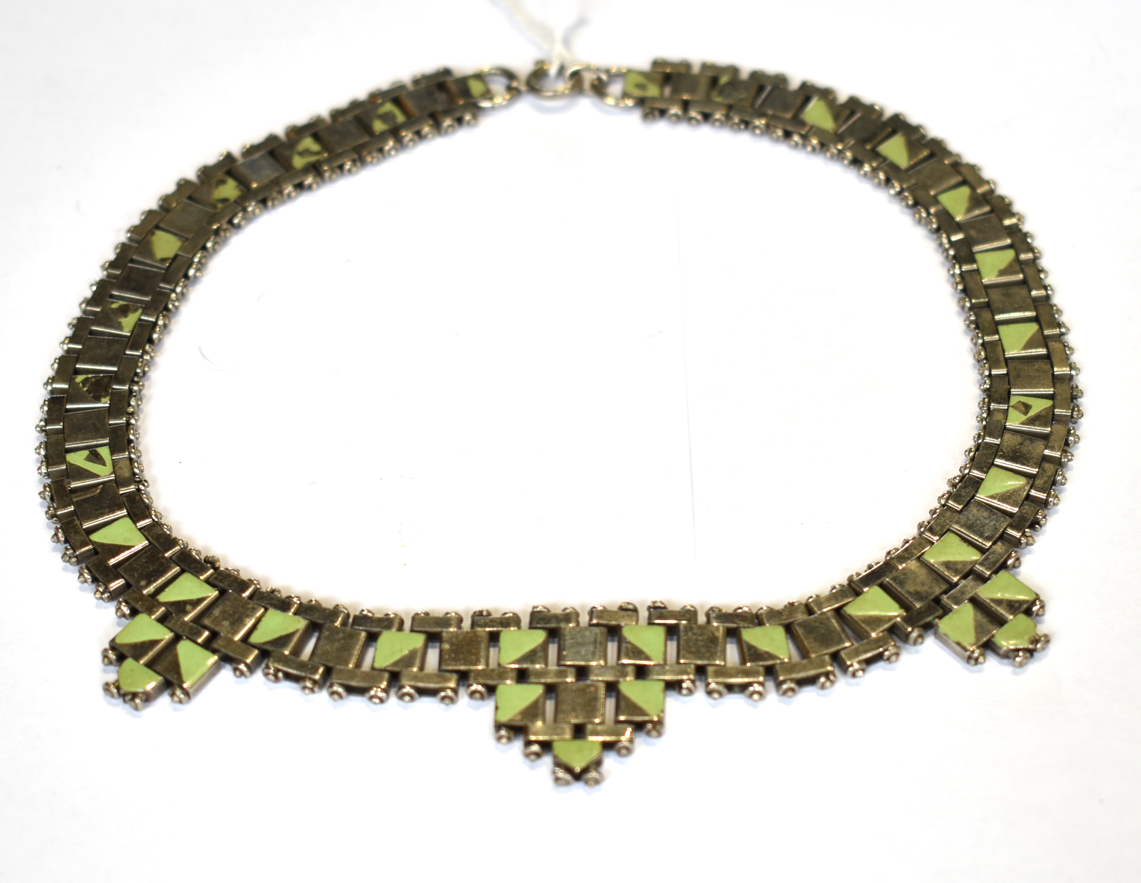 AN ART DECO NICKEL AND GREEN-GEOMETRIC-ENAMELLED BLOCK NECKLACE with three graduated tapering drops,
