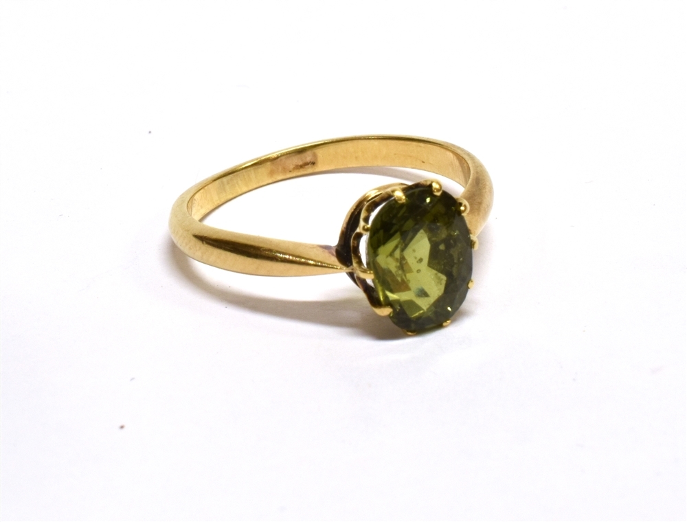 AN EARLY 20TH CENTURY GOLD AND GREEN CHRYSOBERYL SINGLE STONE RING, the oval native-cut stone approx