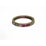 A MID-20TH CENTURY RUBY AND DIAMOND ETERNITY RING alternately grain set in white with groups of