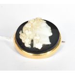 A GOLD AND SARDONYX CAMEO ROUND BROOCH DEPICTING A BACCHANTE with trailing fruiting vines in her