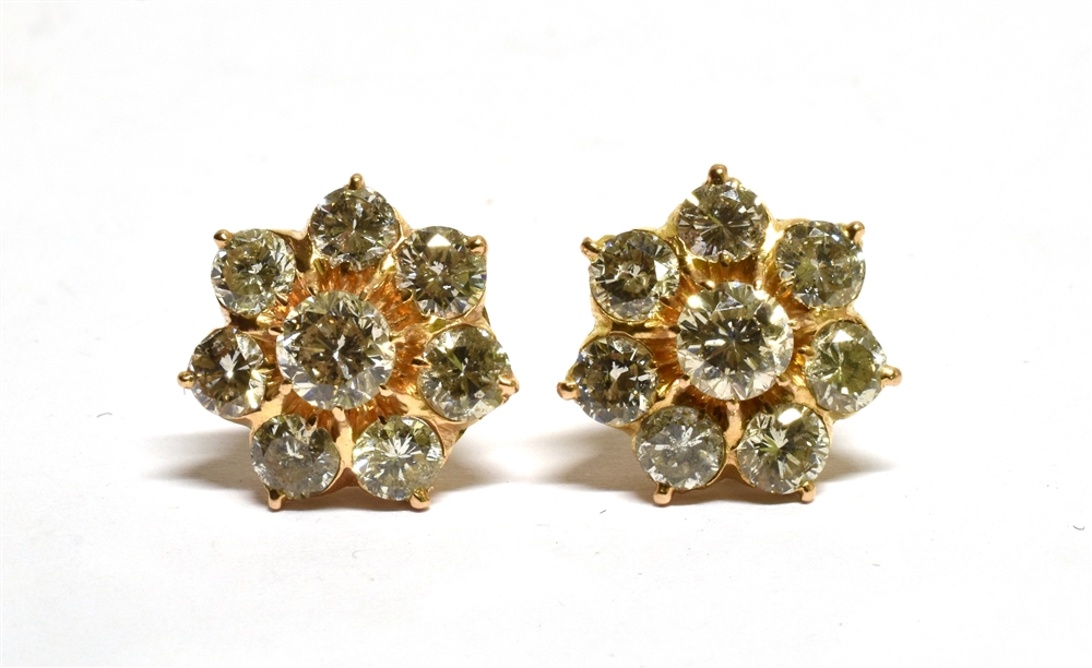 A PAIR OF DIAMOND FLOWER-HEAD CLUSTER STUD EARRINGS each claw set at the centre with a round