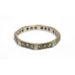 A MID 20TH CENTURY DIAMOND FACETTED ETERNITY RING of octagonal outline, each facet grain-set with