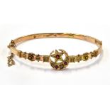 AN EDWARDIAN 9CT ROSE GOLD RED PASTE AND DIAMOND HOLLOW HINGED BANGLE the front designed as a star