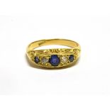 AN EARLY 20TH CENTURY GOLD, SAPPHIRE AND DIAMOND GYPSY RING centred with a round mixed-cut