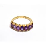 A 9CT GOLD AND OVAL AMETHYST SEVEN STONE RING the mixed-cut stones claw set between V-shaped