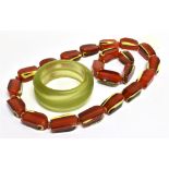 A RED, YELLOW AND BLACK LAYERED-PLASTIC ABSTRACT-OBLONG BEAD NECKLACE AND A MATCHING BRACELET the