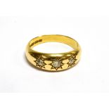 AN EARLY 20TH CENTURY GOLD AND DIAMOND THREE STONE GYPSY RING the graduated old-cut stones star-