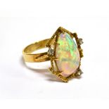 AN MODERN OPAL AND DIAMOND DRESS RING the pear-shaped white opal displays a pleasing play of