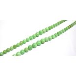 A JADEITE BEAD TWO ROW NECKLACE the rows of 55 & 59 slightly mottled light-green round beads