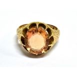 A LATE VICTORIAN 15CT GOLD AND 'IMPERIAL' TOPAZ SINGLE STONE RING the oval native-cut stone