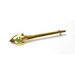 A STYLISH ART NOUVEAU GOLD AND PERIDOT BROOCH IN THE FORM OF A STYLISED TORCH with an open spear-