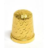 A 9CT GOLD THIMBLE by James Swan & Sons, Birmingham 1897, size 5, with a domed crown and all-over